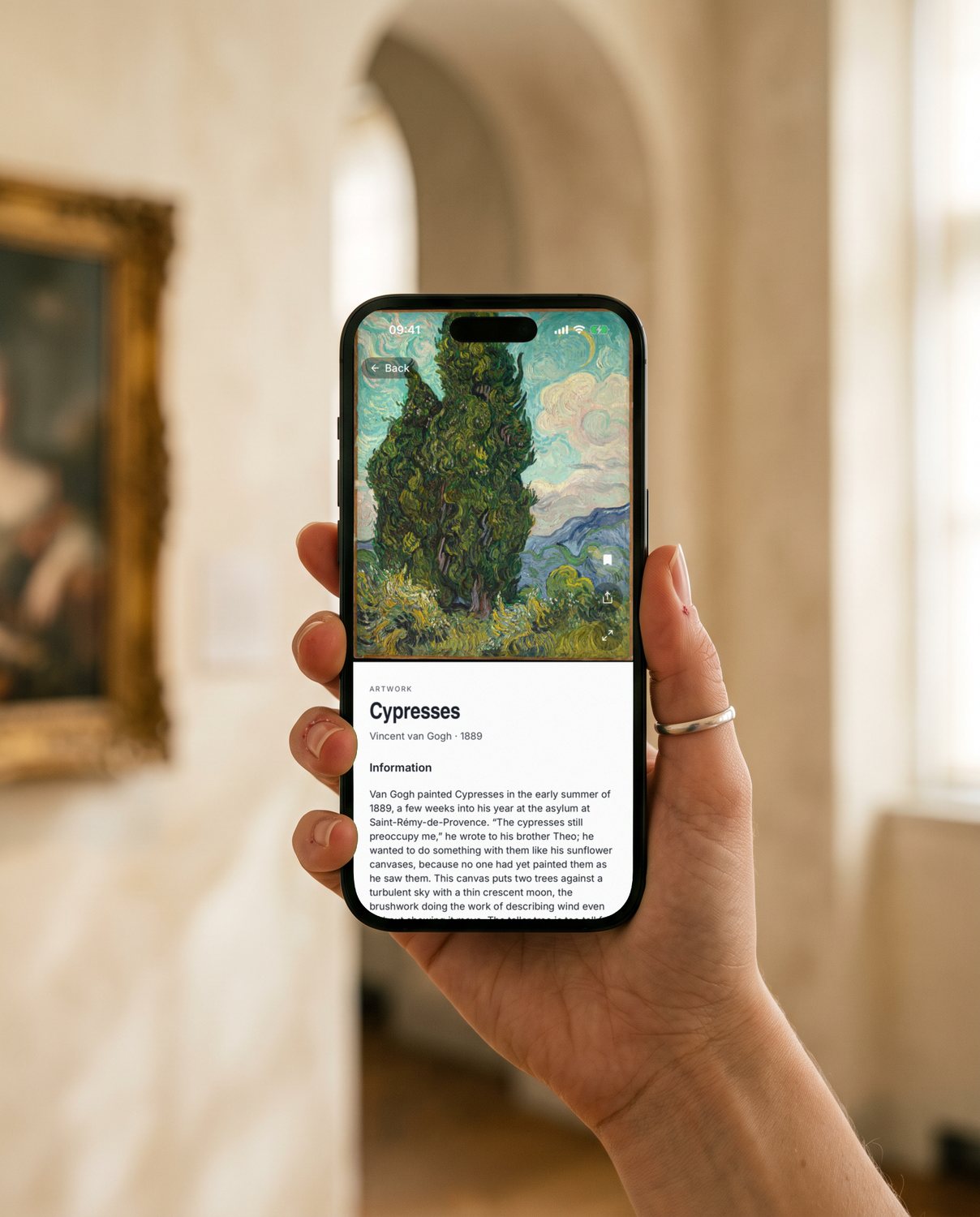 A hand holding an iPhone in a gallery, showing Van Gogh's Cypresses in YEUX.
